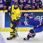 A player from Sweden U 20 ice hockey team is checked by a player from the USA U20 during the World Junior Ice Hockey Championship. World Juniors 2026 featured image