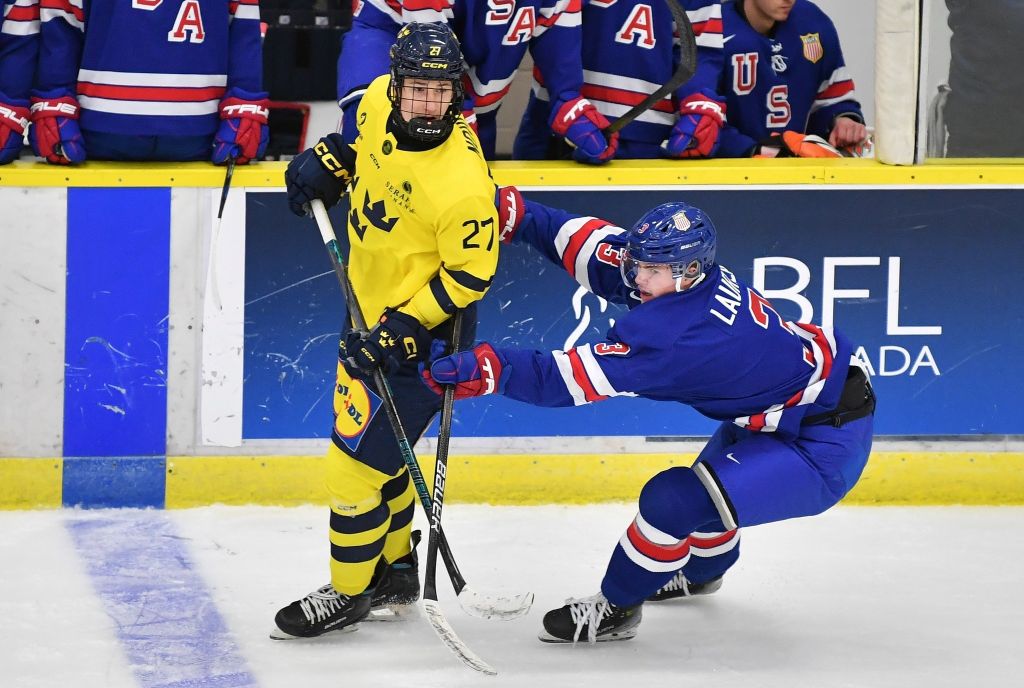 A player from Sweden U 20 ice hockey team is checked by a player from the USA U20 during the World Junior Ice Hockey Championship. World Juniors 2026 featured image