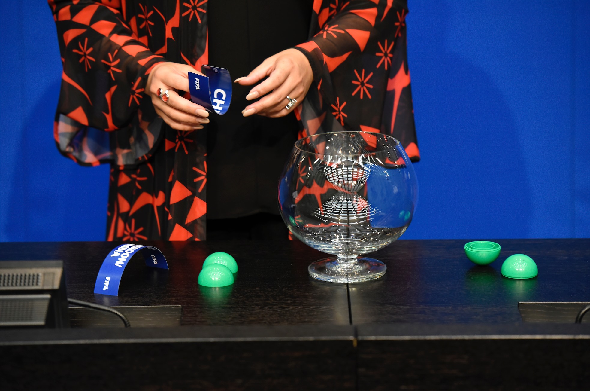 A guest draws the name of a team out of a pot during a FIFA draw. Photo courtesy of the official FIFA Facebook profile. World Cup 2026 draw featured image