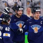 Players from Finland's Olympic ice hockey team celebrate after winning their group in the Winter Olympics 2022. Finland would go on to win the Gold medal. Ice hockey Olympics 2026 article featured image
