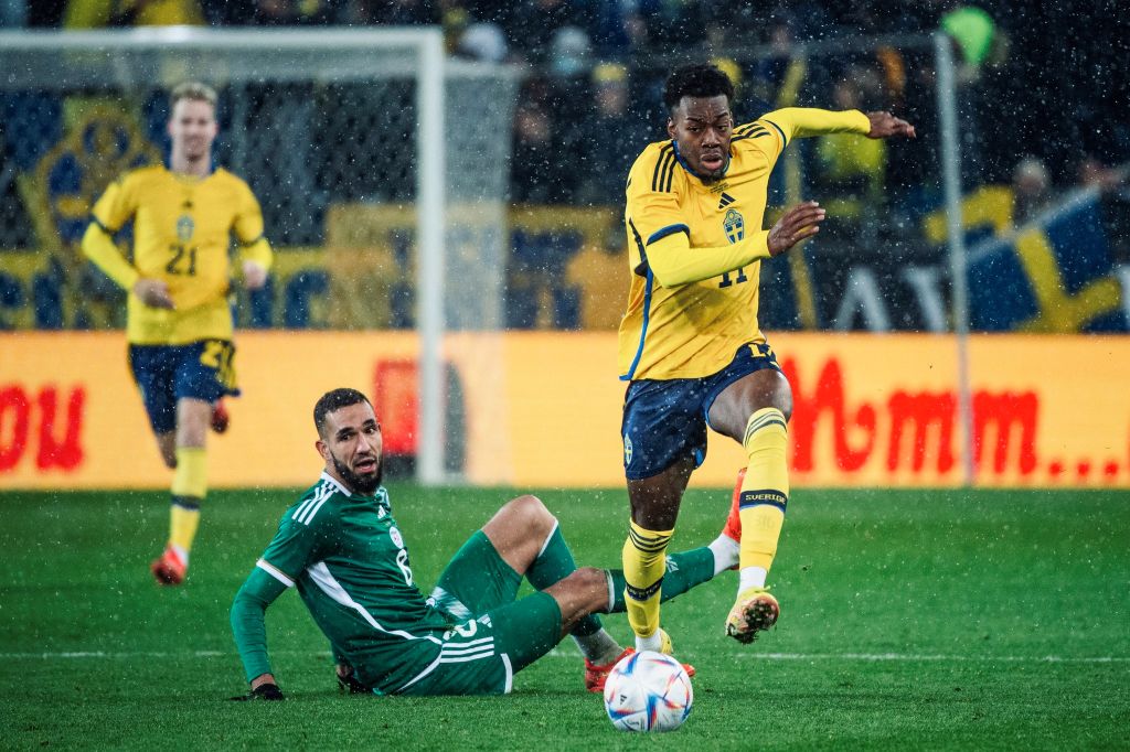 Anthony Elanga from Sweden runs past a player from Algeria during a friendly in 2022. Featured image of the World Cup playoffs primer
